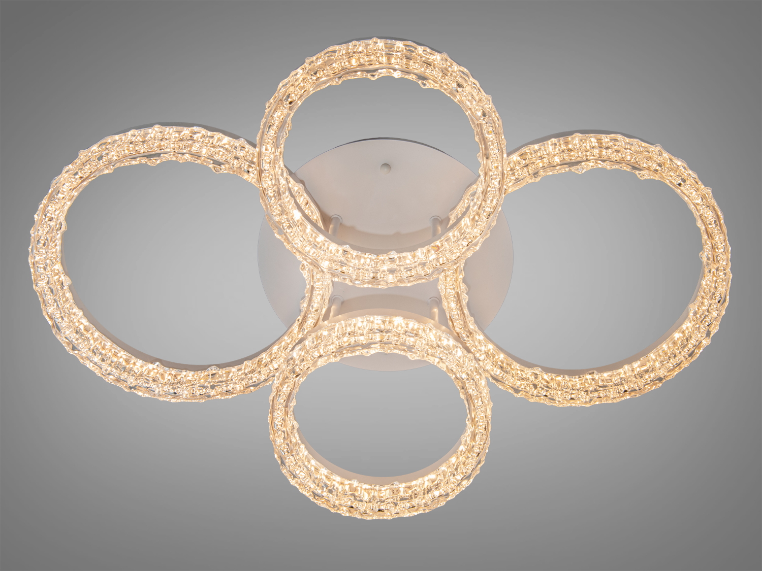 Світильник з чотирма кільцями, що випромінюють тепле світло. Ідеально підходить для затишного інтер’єру.