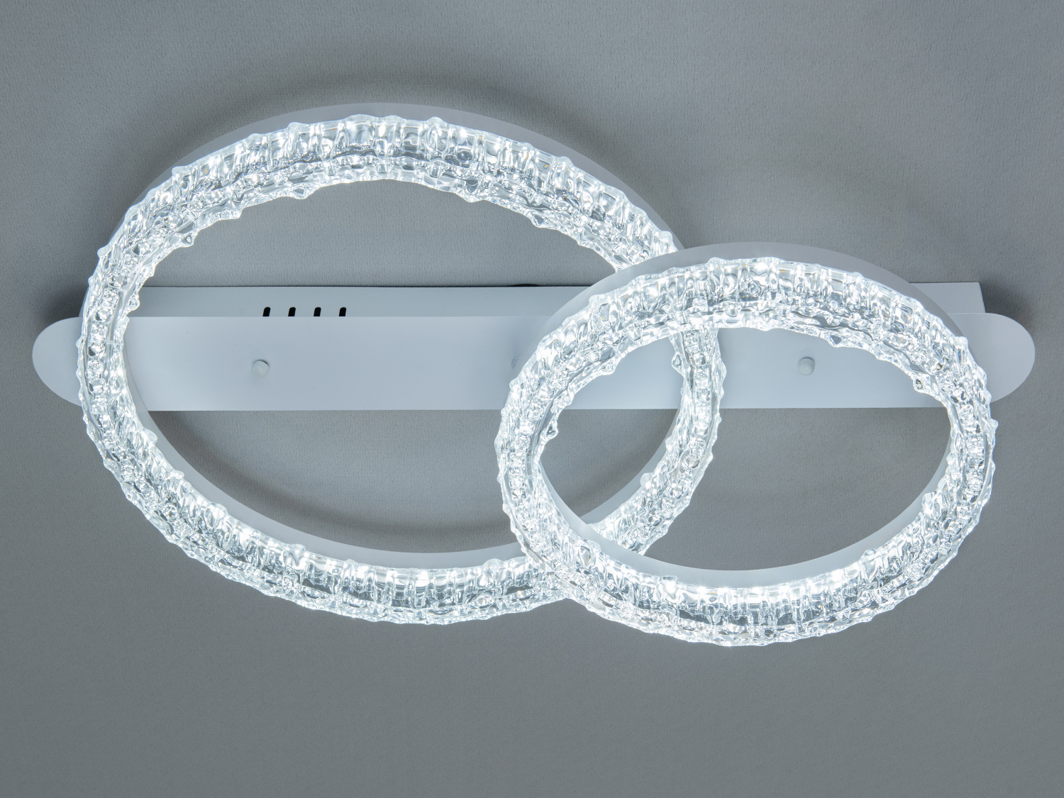 Стельовий світильник із прозорими кільцями, що випромінюють холодне біле світло. Підходить для офісного простору.