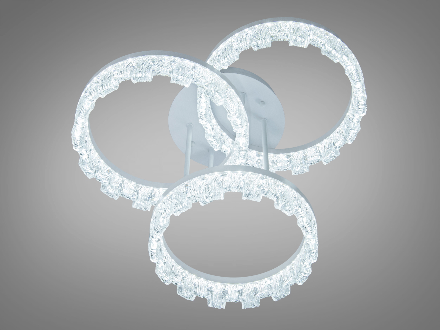 Світильник з трьома кільцями, виготовлений з прозорого матеріалу, створює холодне біле світло. Підходить для сучасного інтер’єру.