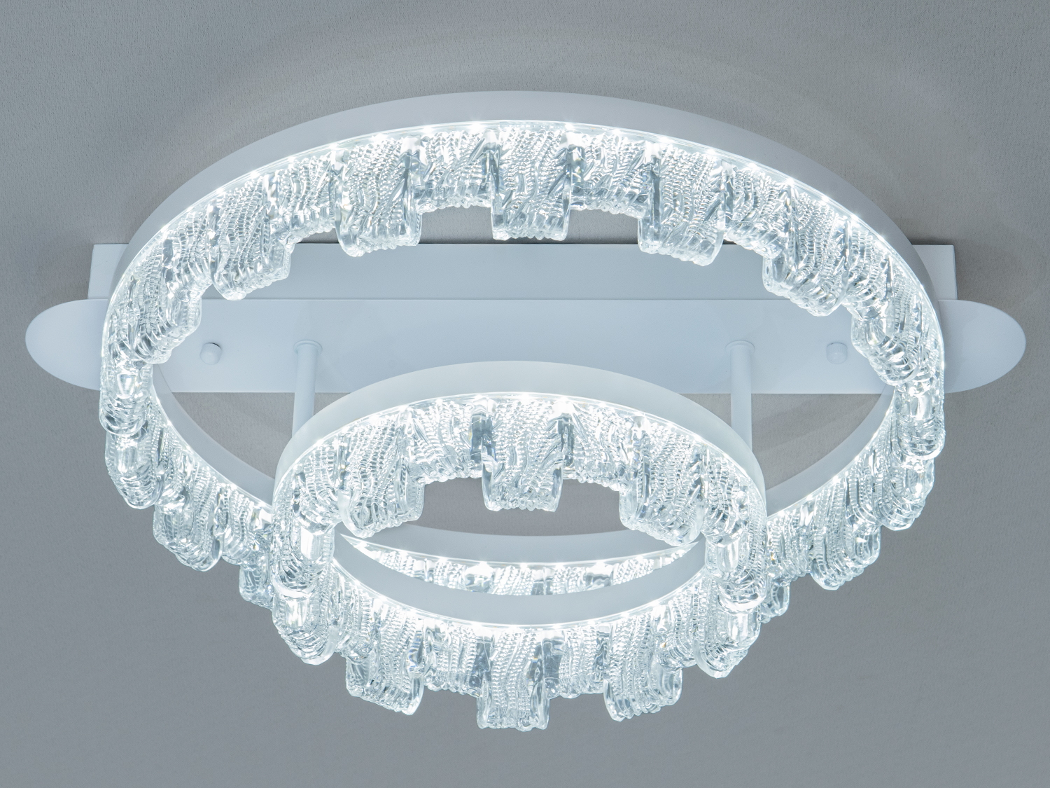 Стельовий світильник з двома кільцями, що випромінюють холодне світло. Підходить для мінімалістичного дизайну.