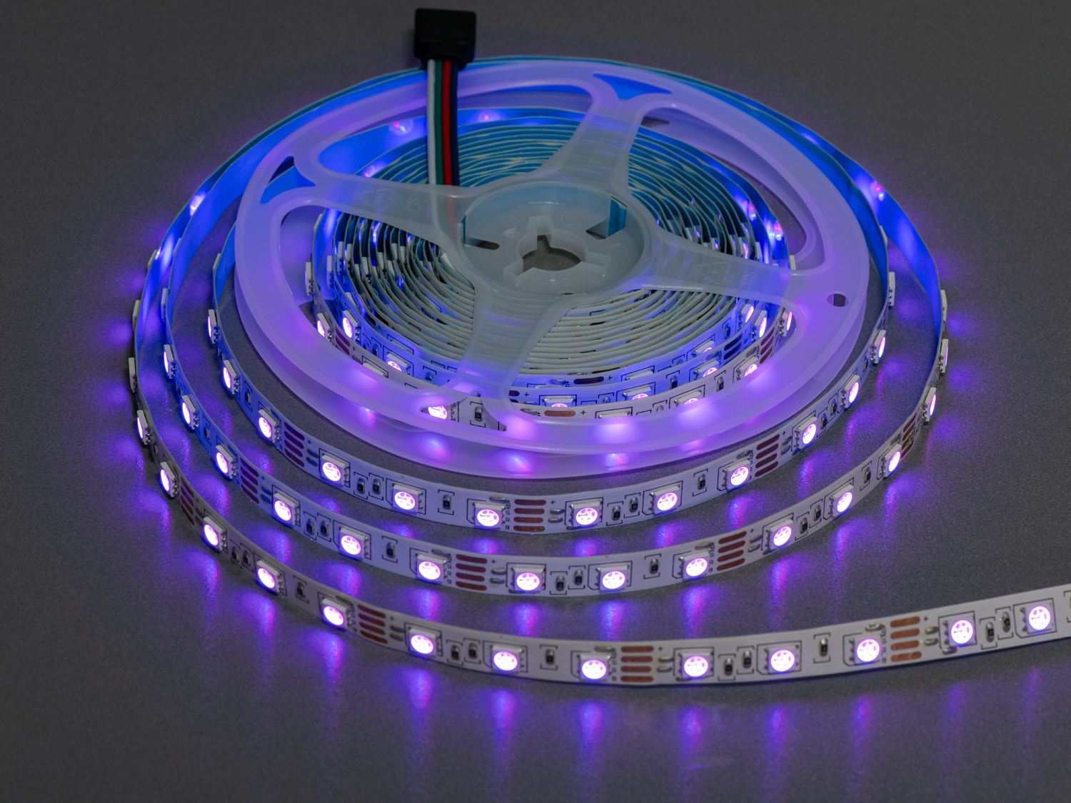 Світлодіодна стрічка з фіолетовим світлом на котушці, підходить для створення атмосферного освітлення.