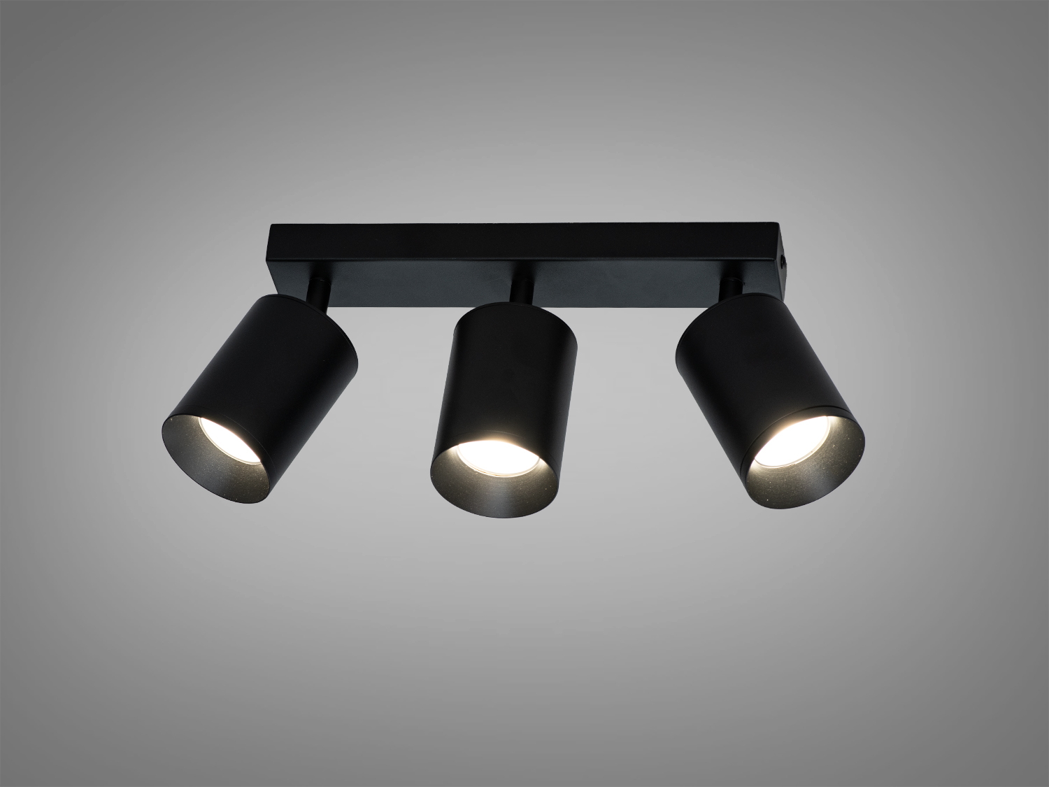 Чорний стельовий світильник з трьома регульованими циліндричними лампами для акцентного освітлення в сучасному інтер′єрі.
