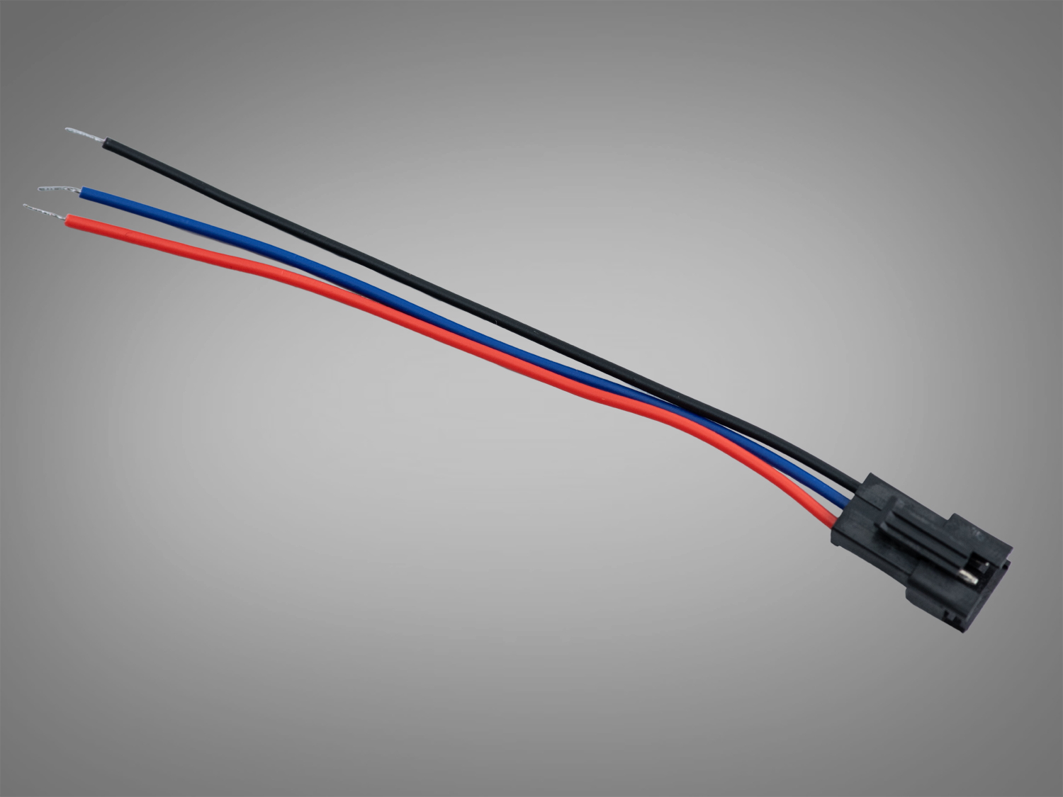 Триколірний електричний кабель з чорним, синім і червоним проводами, оснащений пластиковим роз′ємом для підключення в електричних схемах.