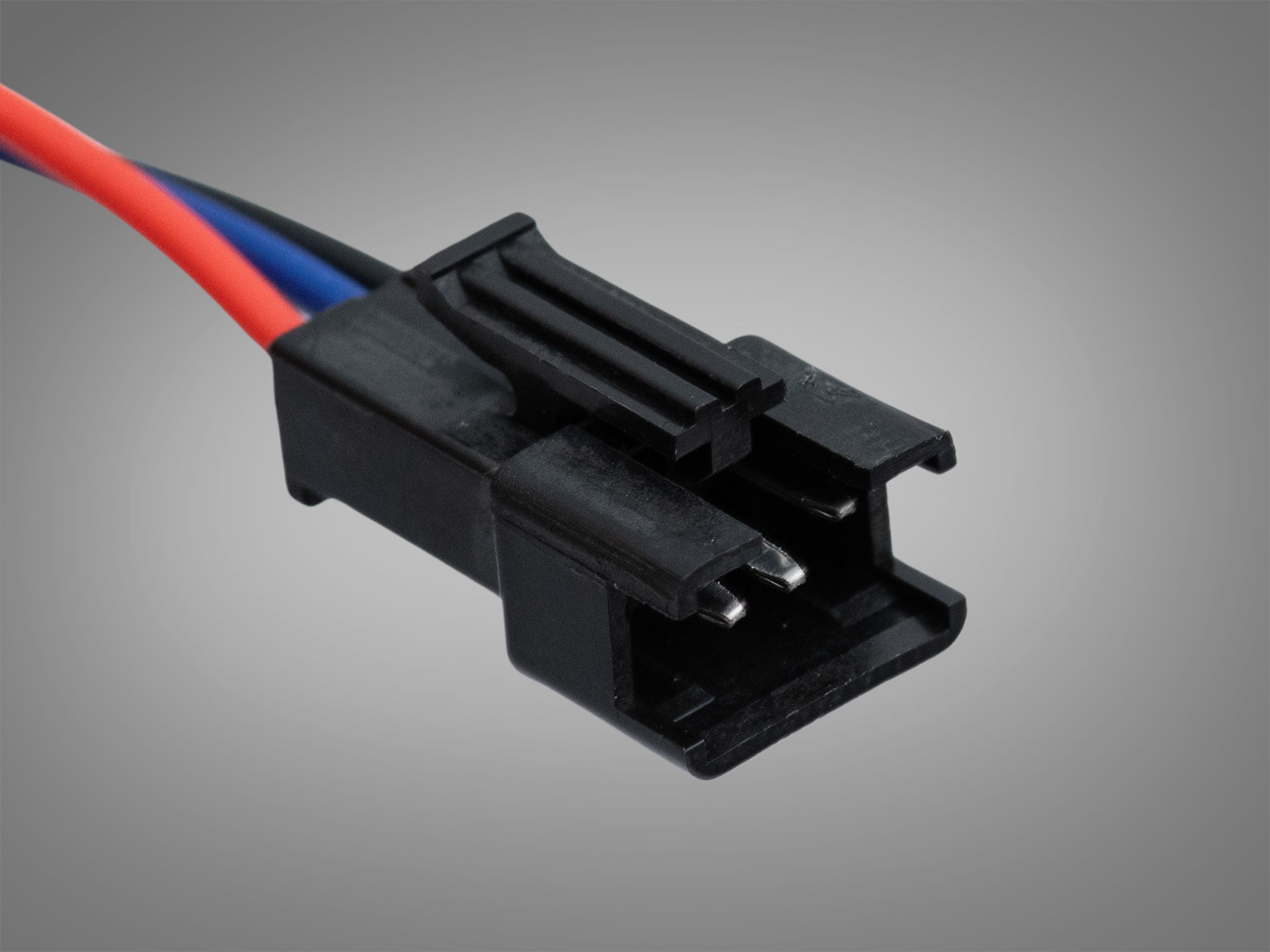 Крупний план чорного пластикового роз′єму з трьома контактами, призначеного для з′єднання електричних компонентів у схемах.