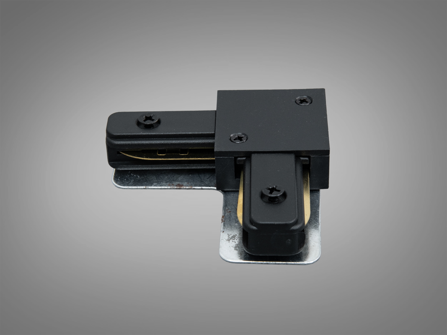 Кутовий з′єднувач для трекового освітлення з чорного пластику, оснащений металевими елементами для надійного монтажу в освітлювальних системах.