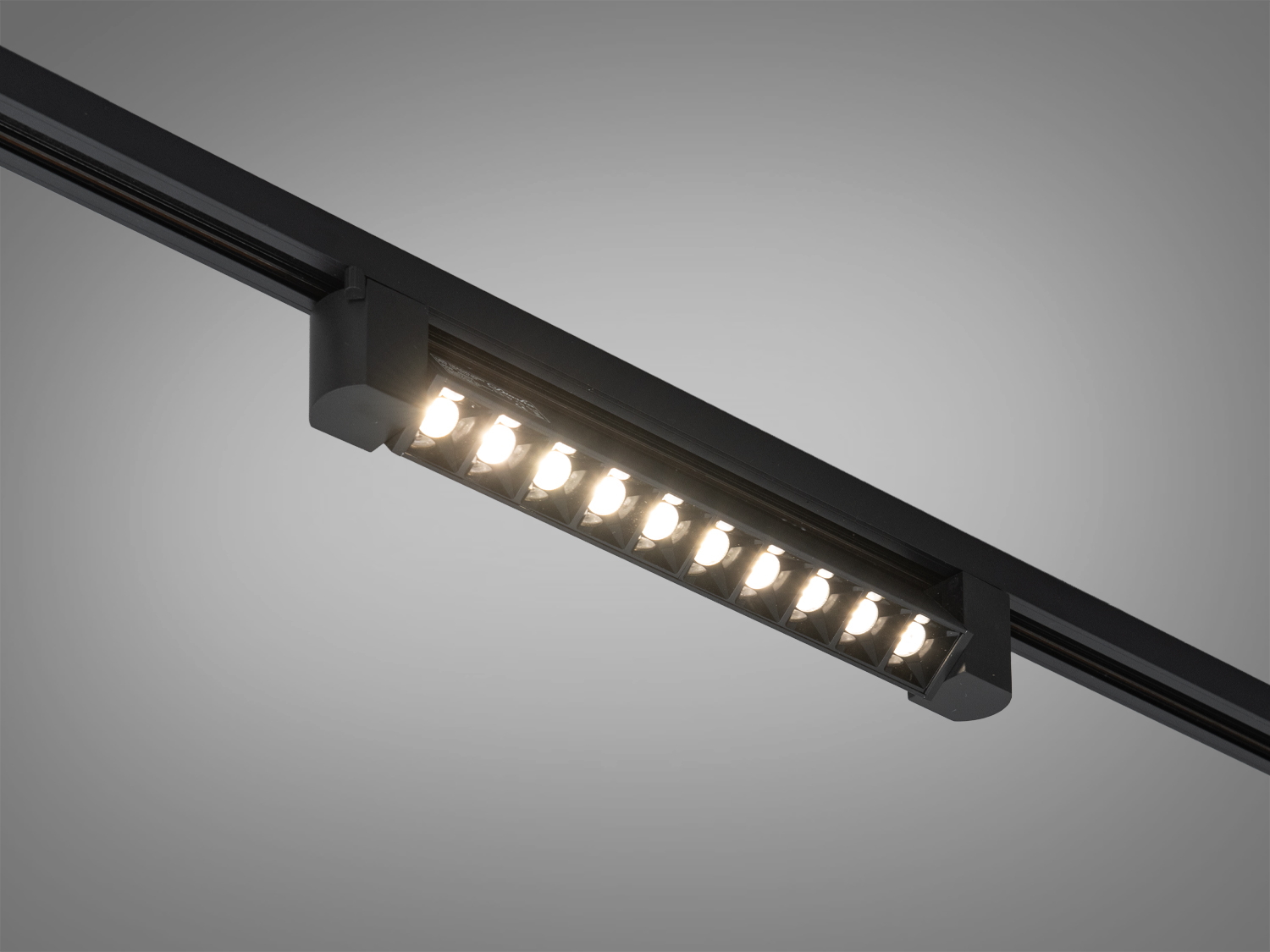 Трековий світильник чорного кольору з лінійними світлодіодами, оптимальний для офісних приміщень.