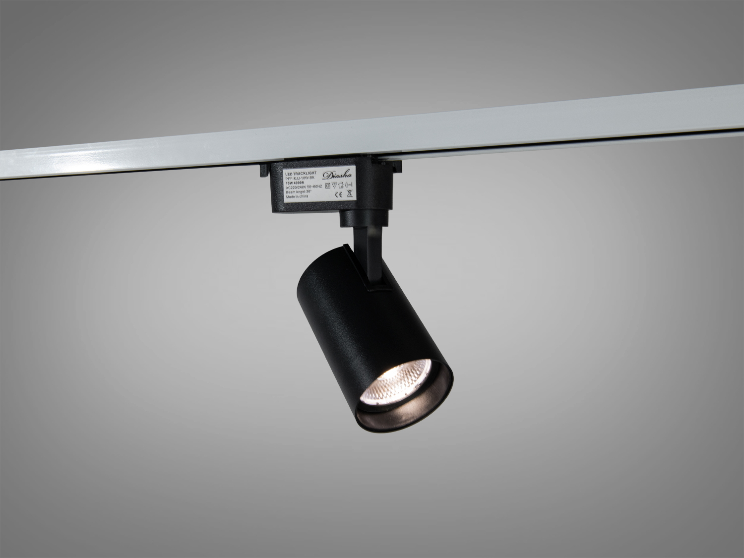 Чорний світильник з циліндричним корпусом, встановлений на шинопровід для акцентного освітлення. Підходить для сучасного інтер′єру.