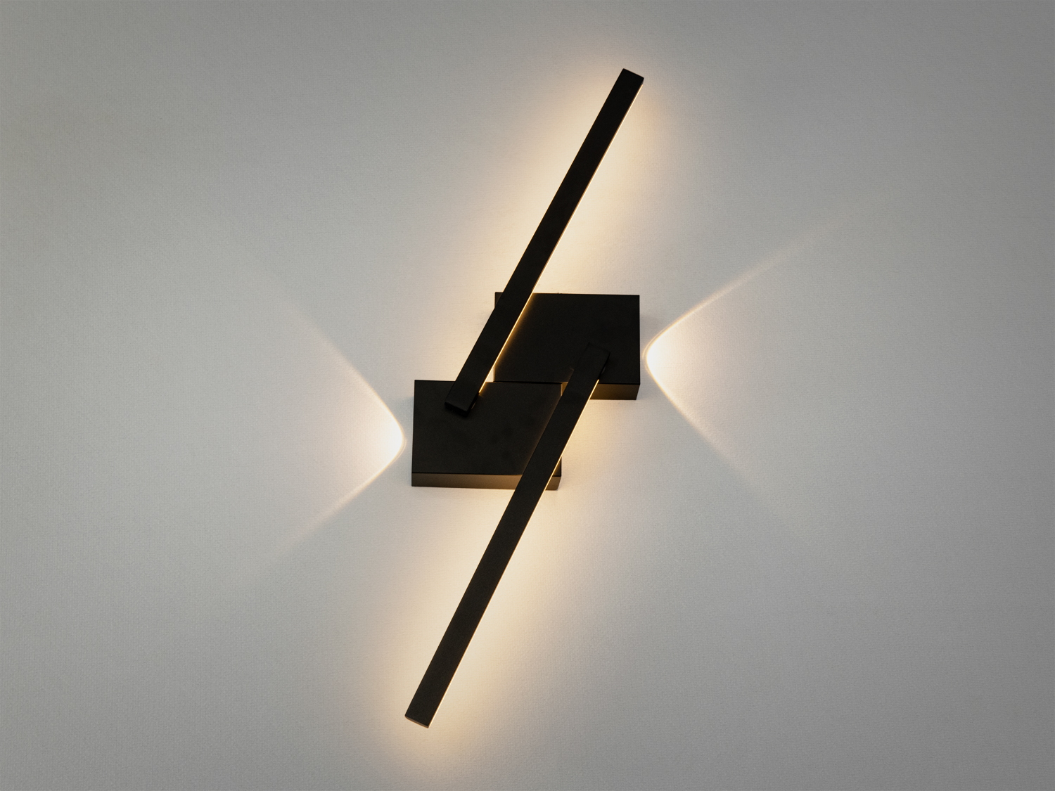 Чорний настінний світильник з двома довгими лініями, що перетинаються, створює м’яке світло для затишної атмосфери в сучасному інтер’єрі.