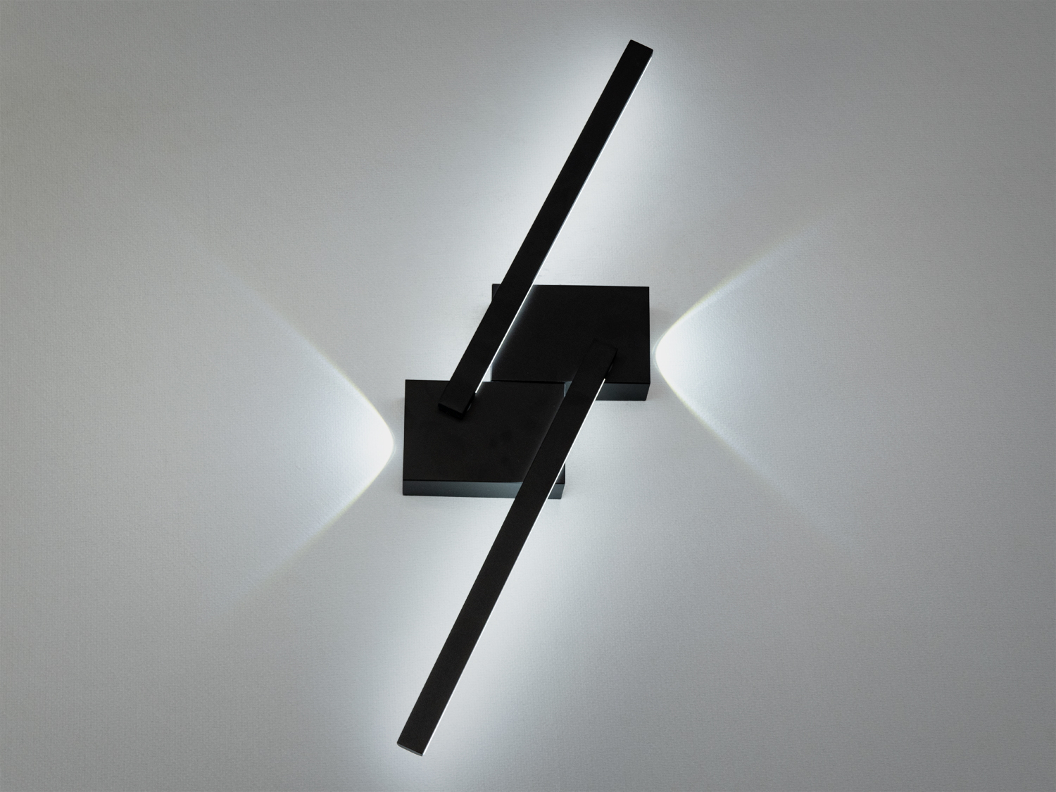 Сучасний настінний світильник з чорним металевим корпусом, випромінює холодне світло, ідеально підходить для мінімалістичного інтер’єру.