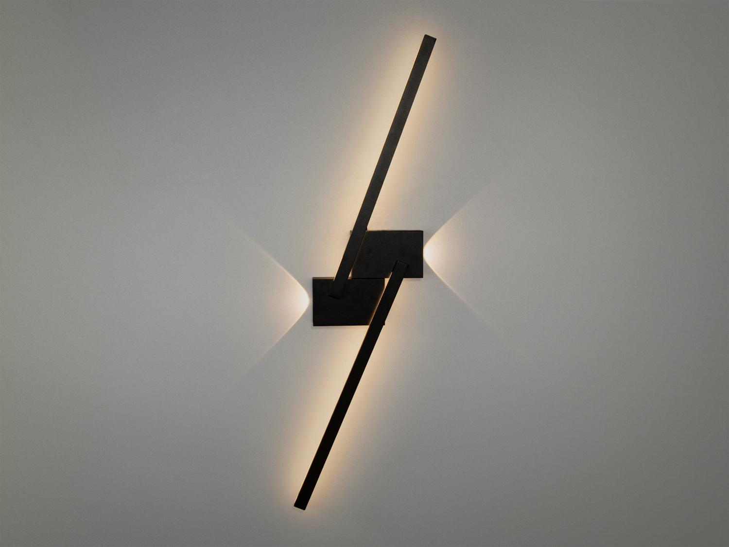 Сучасний настінний світильник з чорними лініями, що перетинаються, створює затишне освітлення. Підходить для вітальні або спальні.
