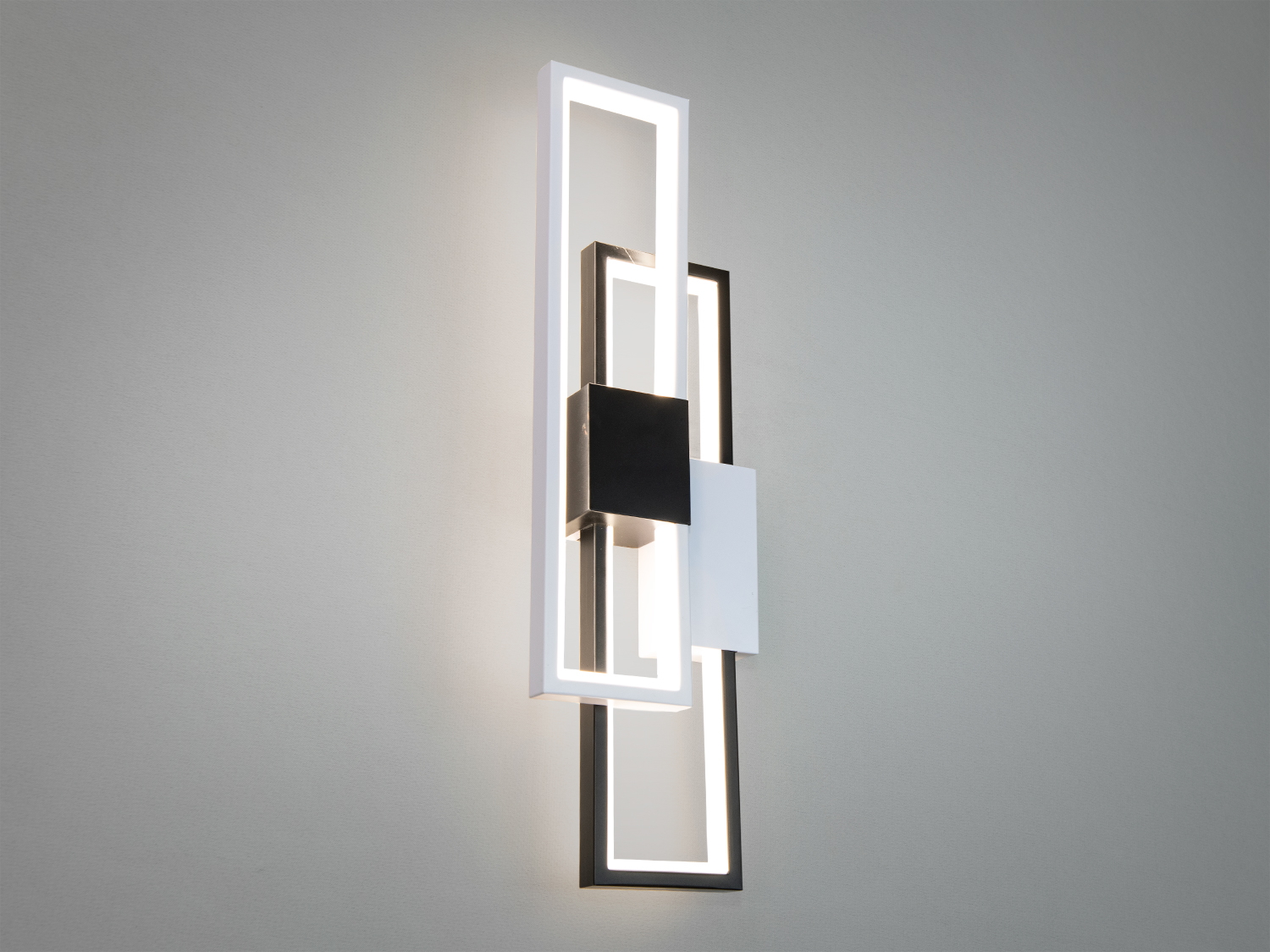 Мінімалістичне LED бра для зали - це справжній зразок мінімалістичного мистецтва, де строга геометрія перетворюється на вишукане джерело світла. Його унікальна форма - переплетення прямокутних рам, виконаних у контрастних білому та чорному кольорах.