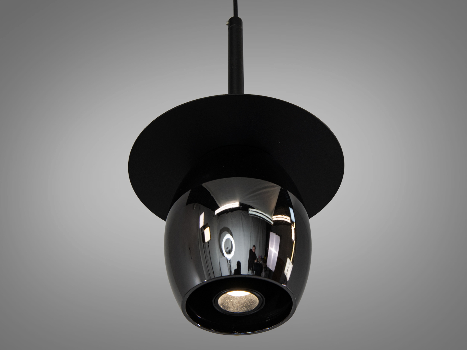 Металевий підвісний світильник з широким круглим диском, чорний, створює спрямоване освітлення. Ідеальний для кухні або їдальні.