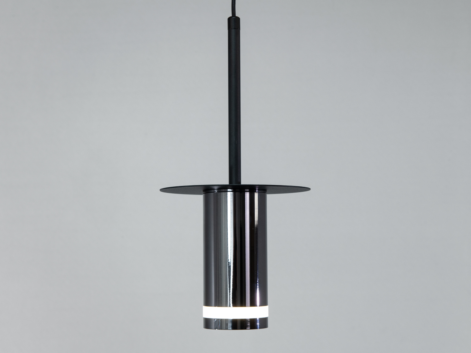 Металевий підвісний світильник з широким круглим диском, чорний, створює спрямоване освітлення. Ідеальний для кухні або їдальні.