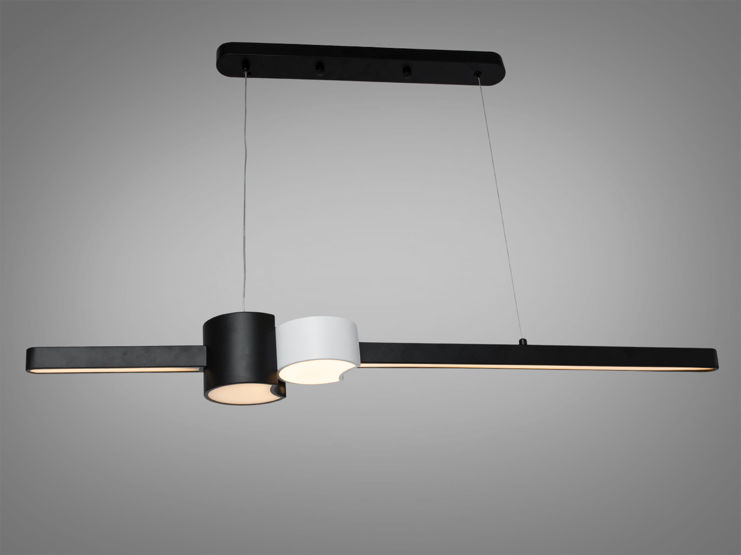 Підвісний світильник з чорним і білим циліндром, тепле світло, металевий корпус, для офісного простору.