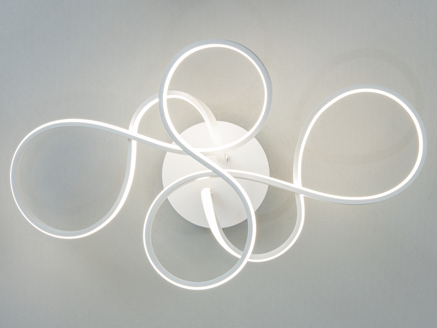 Світильник з білими LED стрічками у вигляді переплетених петель, кріпиться до стелі. Ідеально підходить для сучасного інтер′єру.