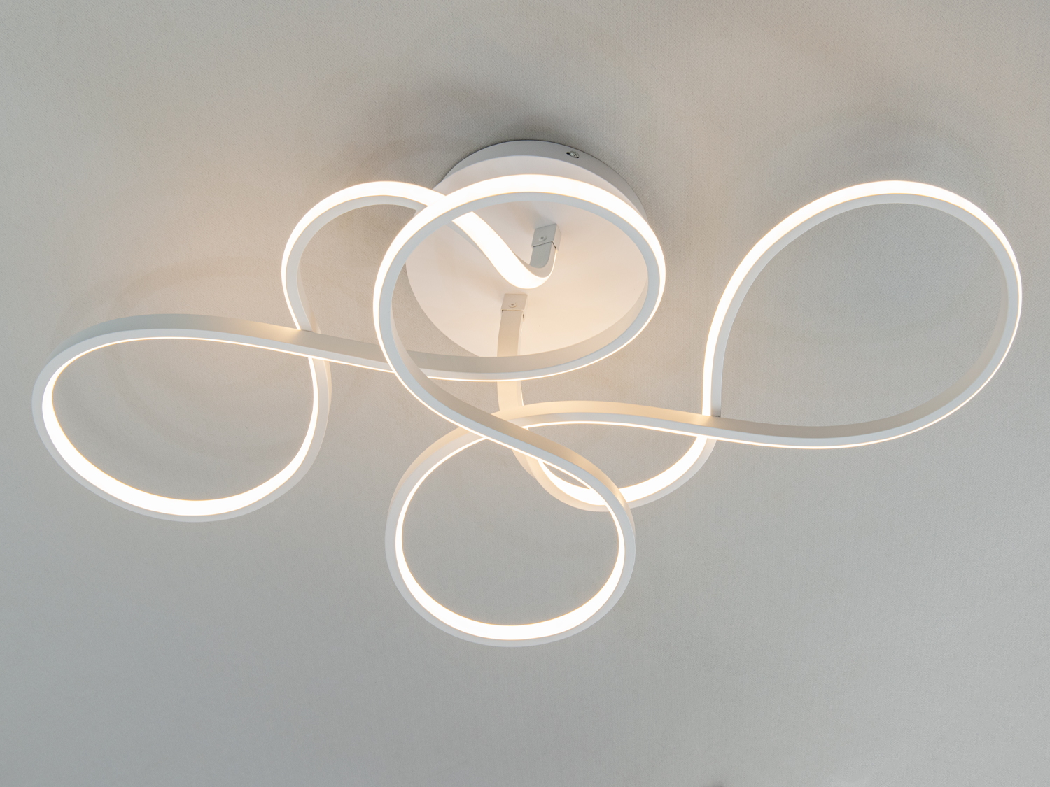 Дизайнерський світильник з білими LED стрічками, що утворюють плавні вигини. Підходить для освітлення вітальні.