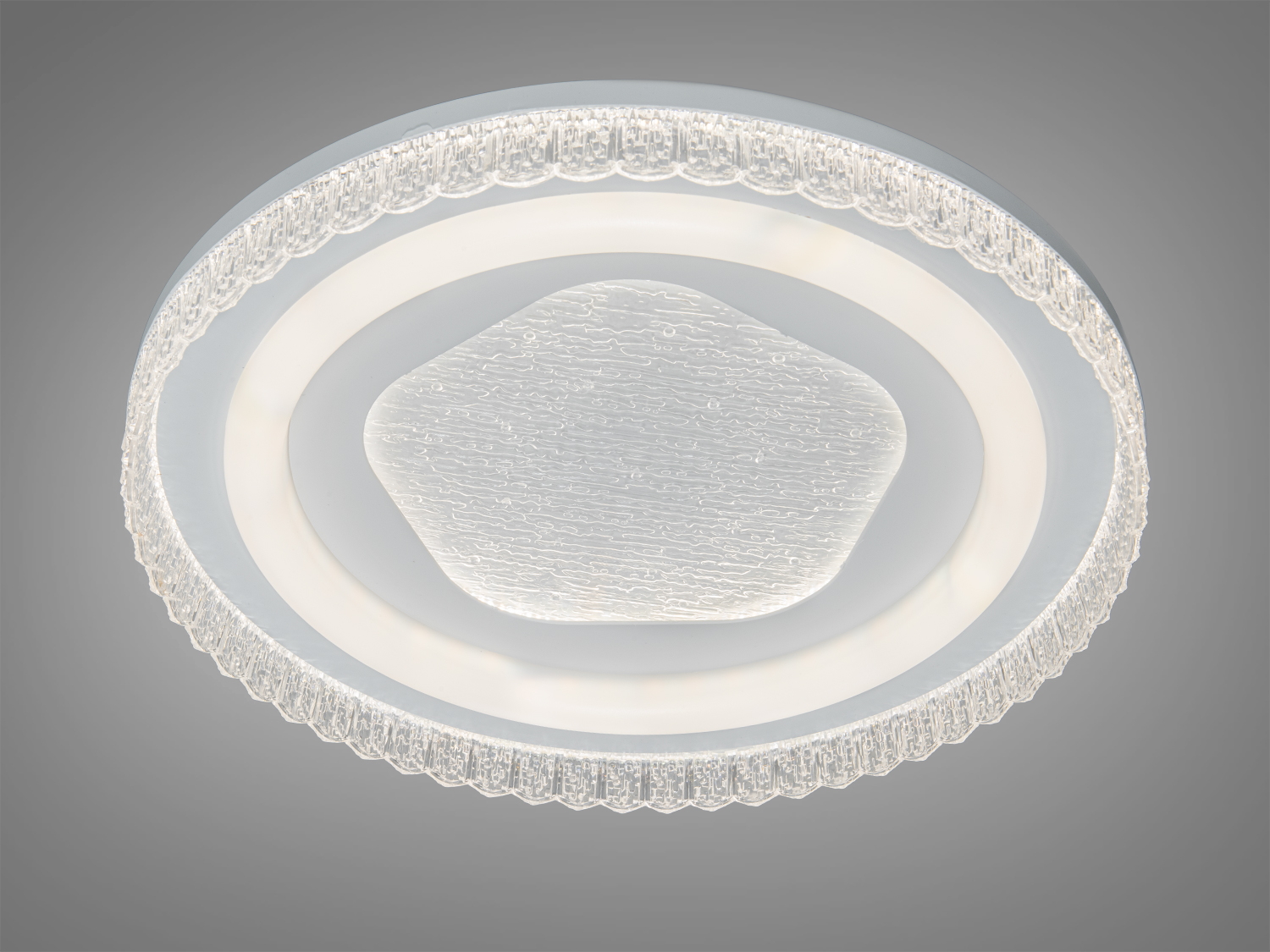 Стельова лампа з текстурованим центром і прозорим обрамленням, що забезпечує рівномірне освітлення. Підходить для будь-якого житлового простору.