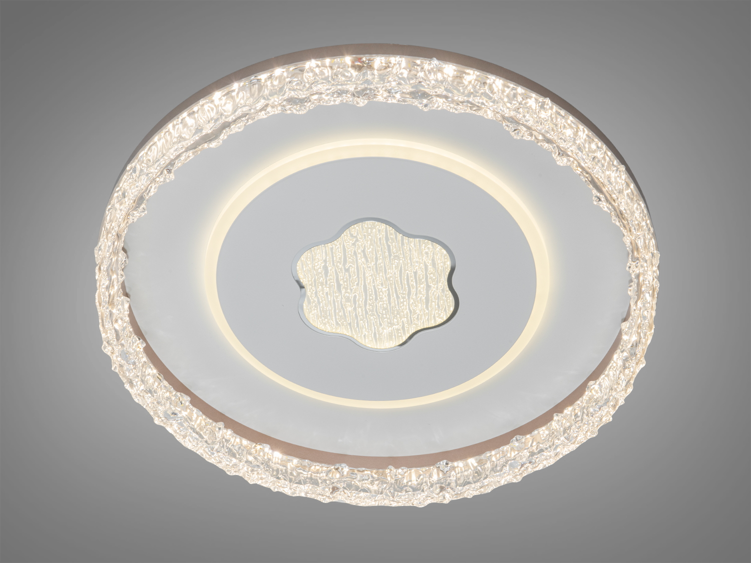 Стельова лампа з центральним декоративним елементом у формі квітки. Випромінює м’яке світло, підходить для вітальні.