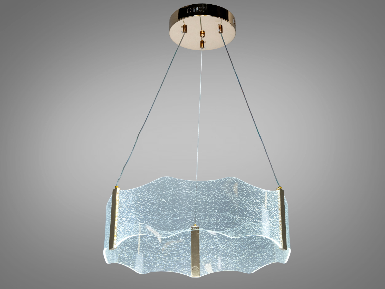 Підвісний світильник з хвилястим скляним абажуром, підвішений на тросах. Призначений для сучасного інтер’єру, створює м’яке розсіяне світло.